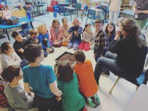 groupe d'enfants assis en cercle dans une classe